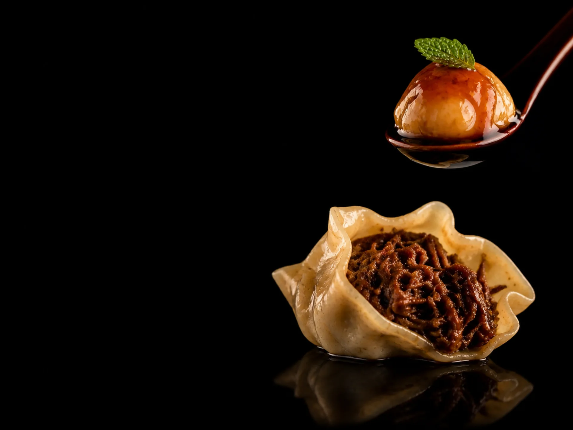 Dos bocados de la cocina de QOM sobre fondo negro